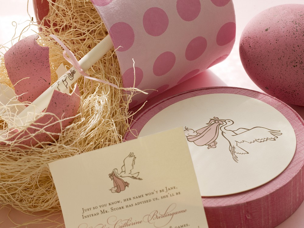 Hand-painted ostrich egg containing rolled baby shower invitation insert