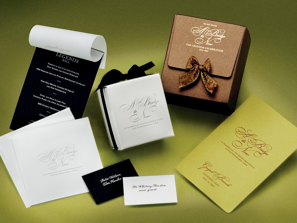 Various event accessories including personalized menu, gift packaging for custom candle and CD's from the musical guests