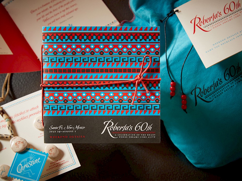 Various event materials including suede welcome pouch and itinerary