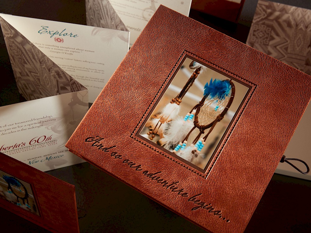 Accordion style hand-bound invitation with leather cord closure